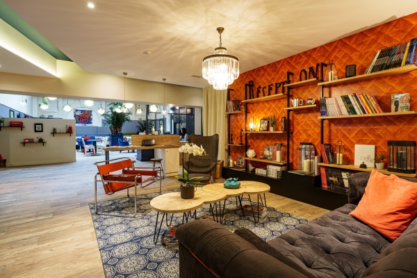 Salon bibliothèque au mur orange – Le Londres, hôtel à Saumur